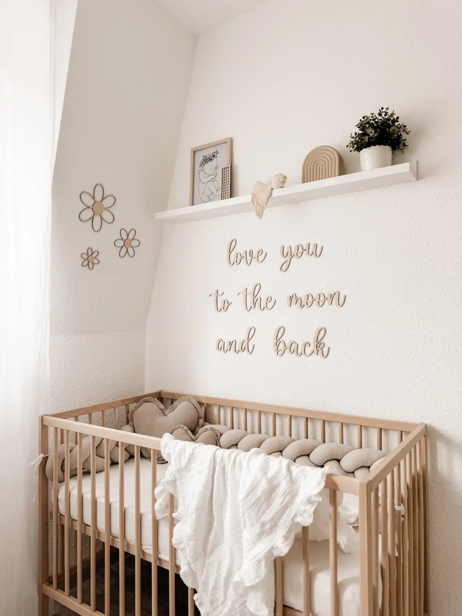 Ein leichter Holzgeflecht-Babybett mit Bettwäsche.