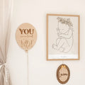 Lightbraunes holz plaque in ballonform mit liebevollem loved ballon text und blumendesign fürs babyzimmer